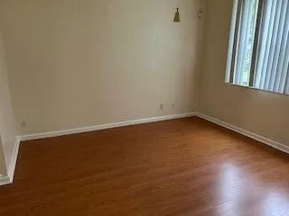 a view of a room with wooden floor and a window
