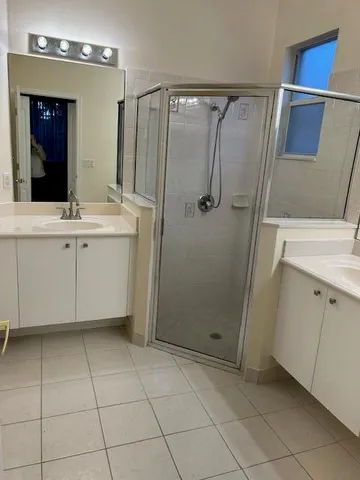 a bathroom with a shower a sink and a mirror