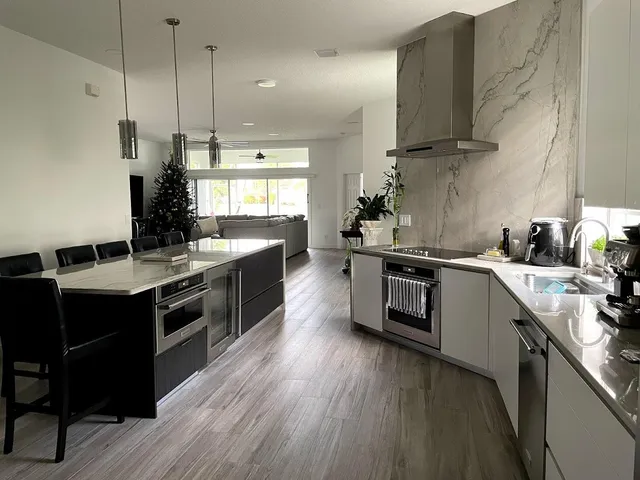 a kitchen with a sink stove and wooden floor