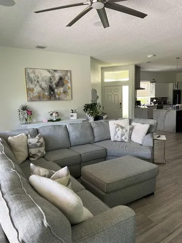 a living room with furniture and a view of kitchen
