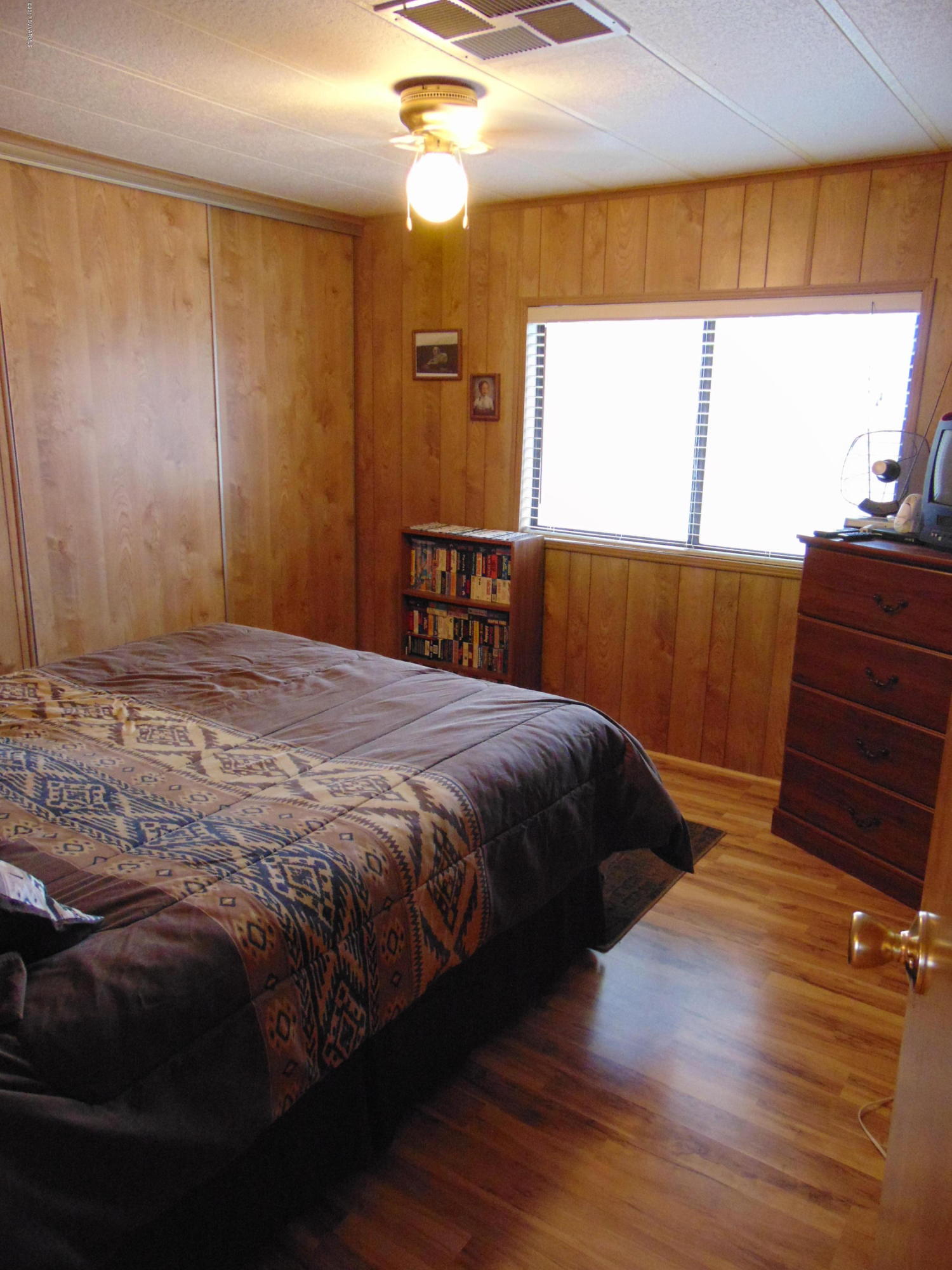 4715 Tagalong Trail Rimrock, AZ 86335 - Photo 16 of 30 a bedroom with a bed a dresser with wooden floor