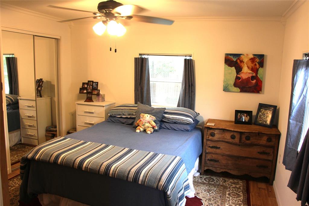 800 Griffin Road Albany, TX 76430 - Photo 11 of 15 a bedroom with a bed and a chandelier