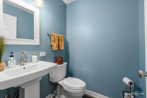 a bathroom with a toilet a sink and mirror