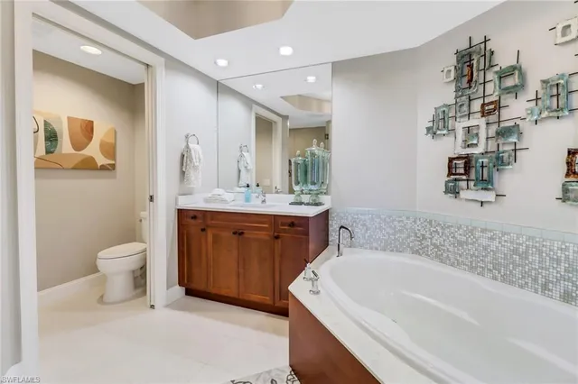 a bathroom with a granite countertop sink a toilet and shower
