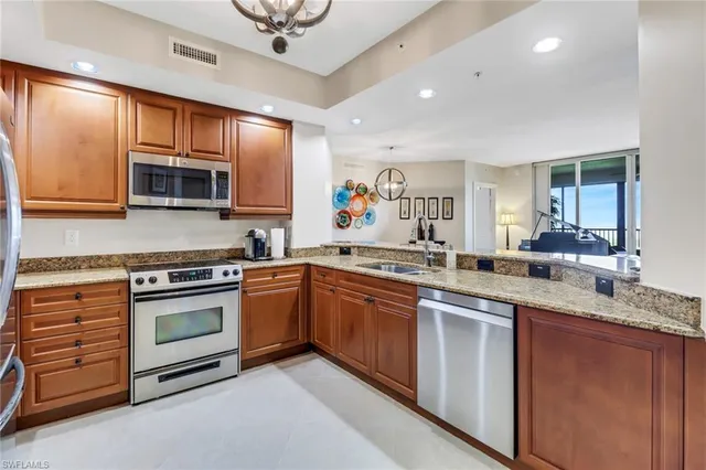 a kitchen with stainless steel appliances granite countertop wooden cabinets sink and stove top oven