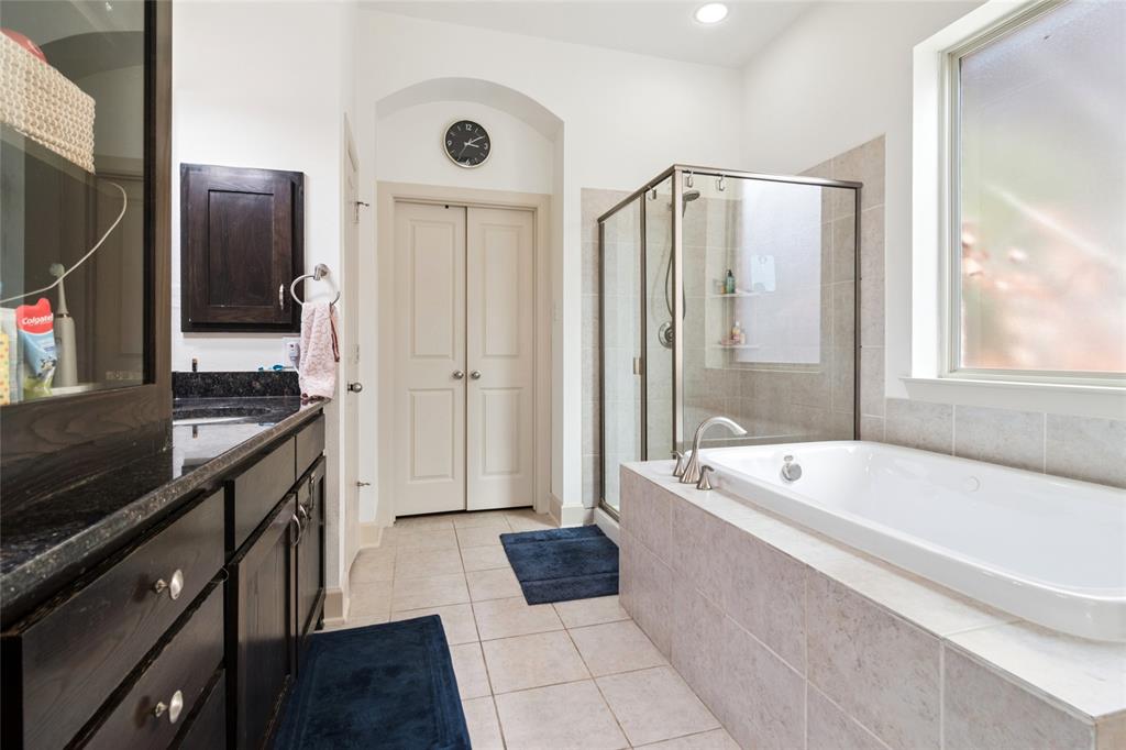 6715 Castillo Street Irving, TX 75039 - Photo 13 of 24 a bathroom with a granite countertop tub sink a mirror and a shower