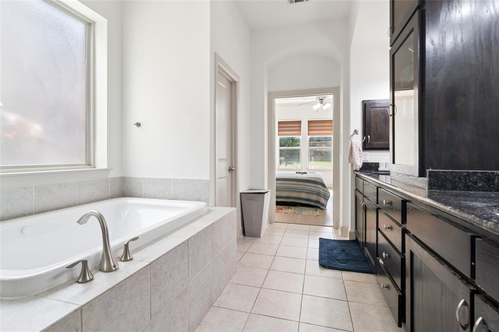 6715 Castillo Street Irving, TX 75039 - Photo 15 of 24 a bathroom with a tub a sink and a large window