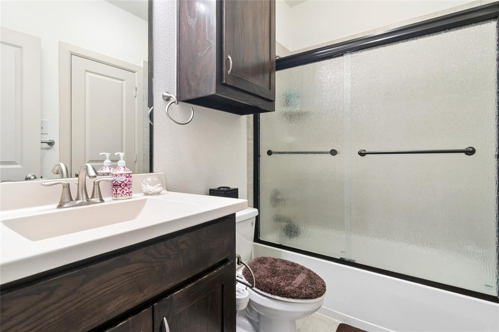 6715 Castillo Street Irving, TX 75039 - Photo 19 of 24 a bathroom with a sink a toilet a mirror and shower