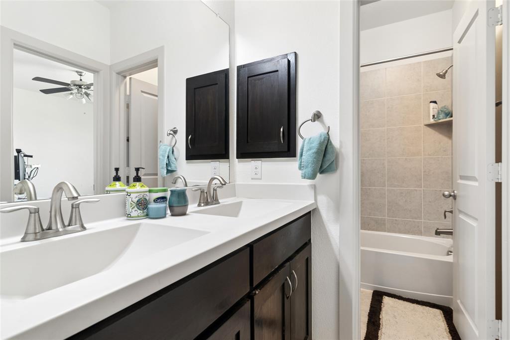 6715 Castillo Street Irving, TX 75039 - Photo 22 of 24 a bathroom with a sink double vanity granite tub shower and a mirror