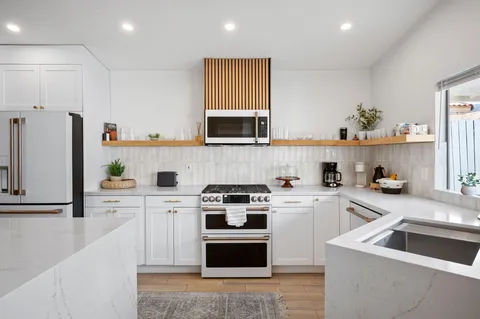 a kitchen with cabinets stainless steel appliances and a sink