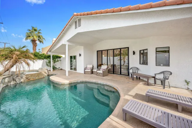 a swimming pool with outdoor seating and yard