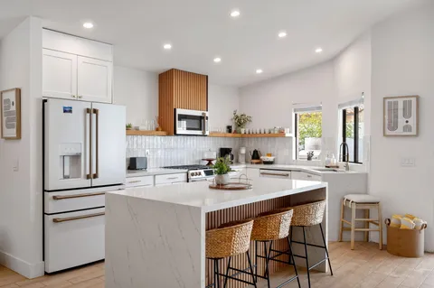 a kitchen with white cabinets and stainless steel appliances