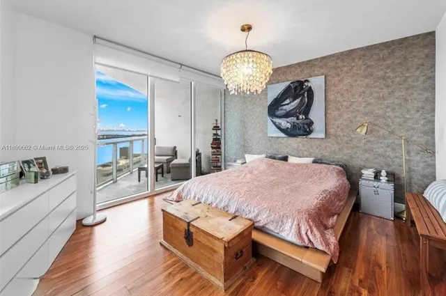 a spacious bedroom with a bed and a chandelier