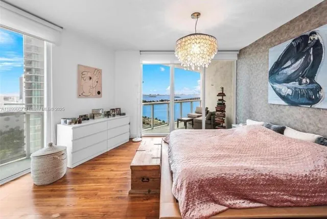 a spacious bedroom with a bed mirror and a window