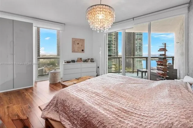 a bedroom with a large bed and a chandelier