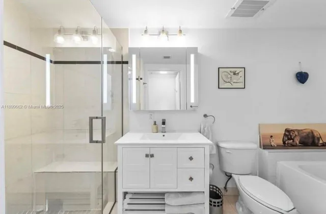 a bathroom with a sink toilet vanity and shower