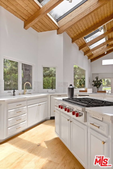 1435 Crest Drive Altadena, CA 91001 - Photo 15 of 54 a kitchen with kitchen island a stove a sink and white cabinets with wooden floor
