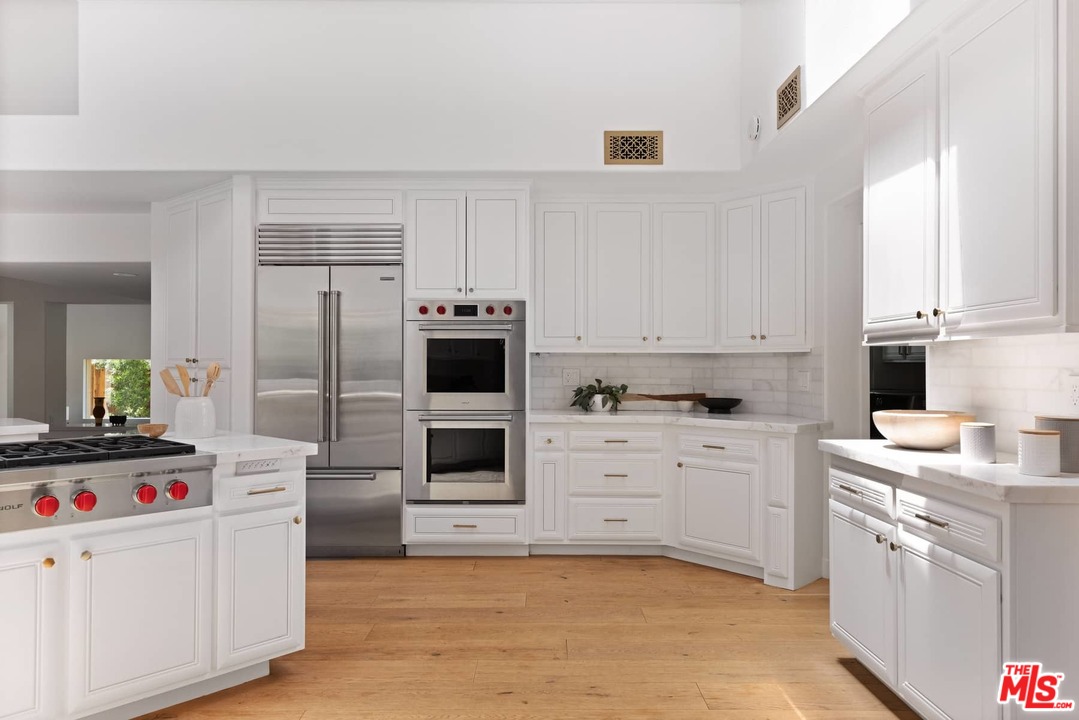 1435 Crest Drive Altadena, CA 91001 - Photo 17 of 54 a kitchen with white cabinets and stainless steel appliances