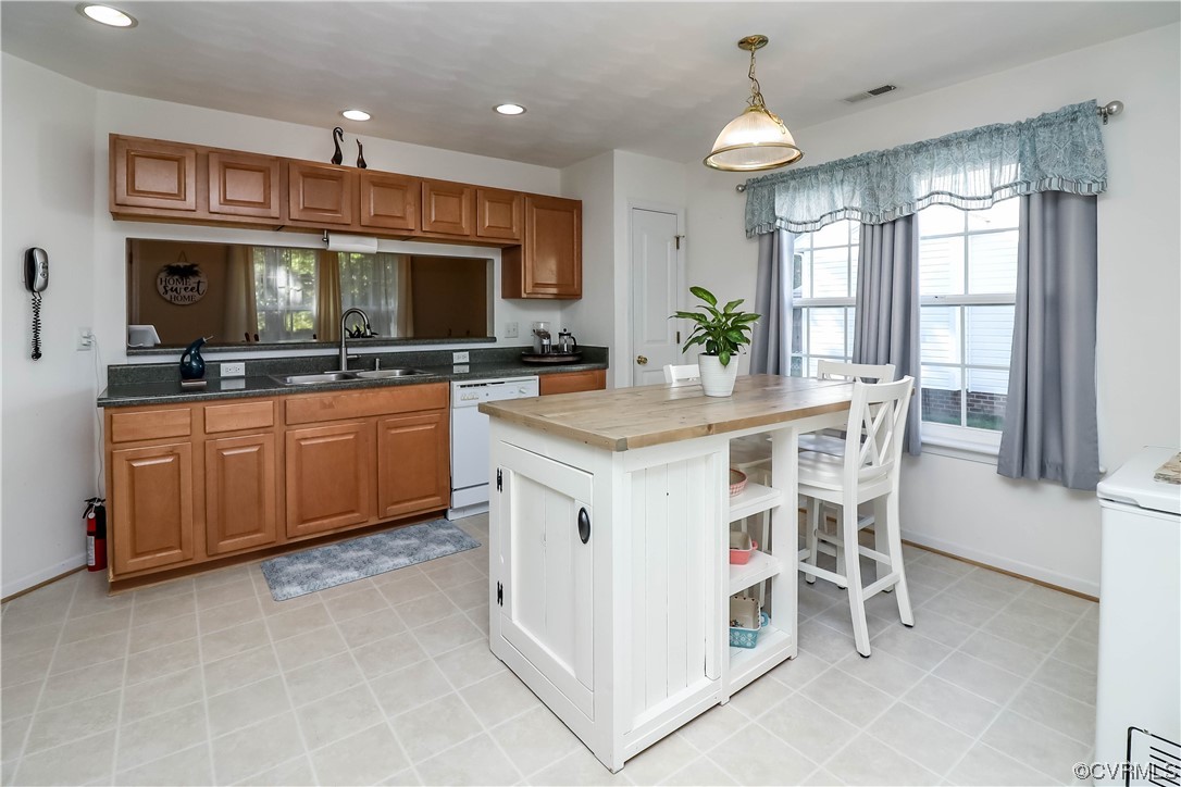 9219 Alcove Grove Road Chesterfield, VA 23832 - Photo 13 of 41 a kitchen with a stove a sink a dining table and chairs