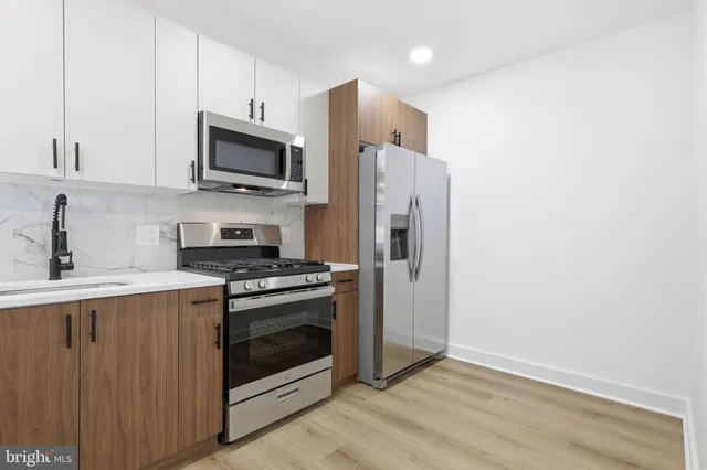a kitchen with stainless steel appliances a stove a sink and a microwave