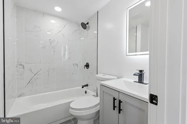 a bathroom with a sink toilet a mirror and shower