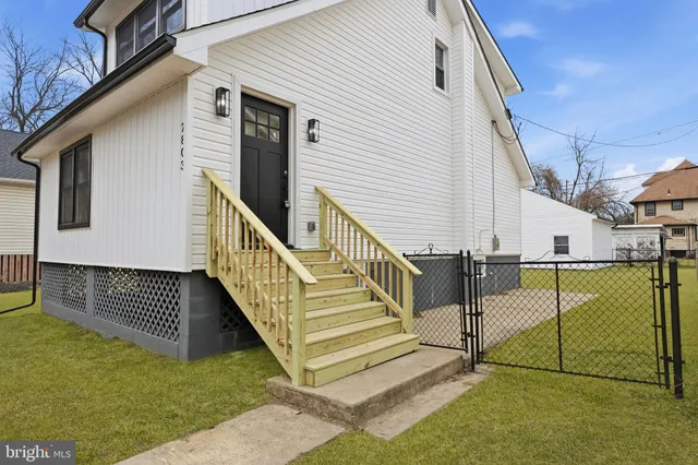 a view of a house with wooden walls and wooden fence