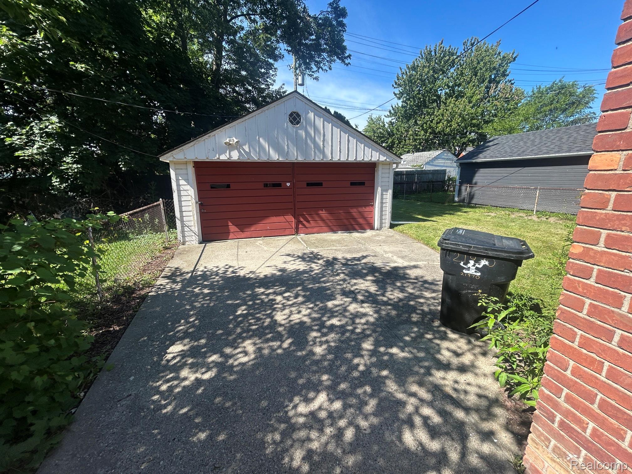 21970 Moross Road Grosse Pointe, MI 48236 - Photo 19 of 21 Detached two-car garage with white siding and red overhead doors