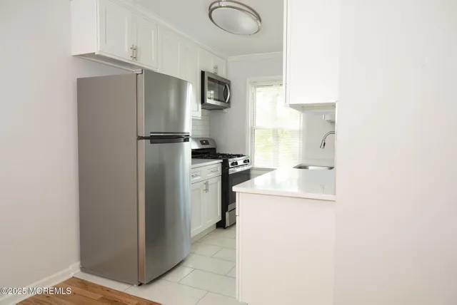 a kitchen with a refrigerator sink stove and cabinets
