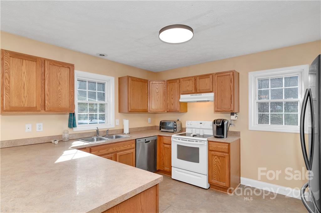 6144 Soco Road Maggie Valley, NC 28751 - Photo 7 of 23 a kitchen with a sink stove and cabinets