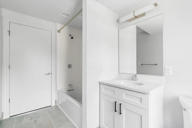 a bathroom with a bathtub a sink a vanity and a mirror