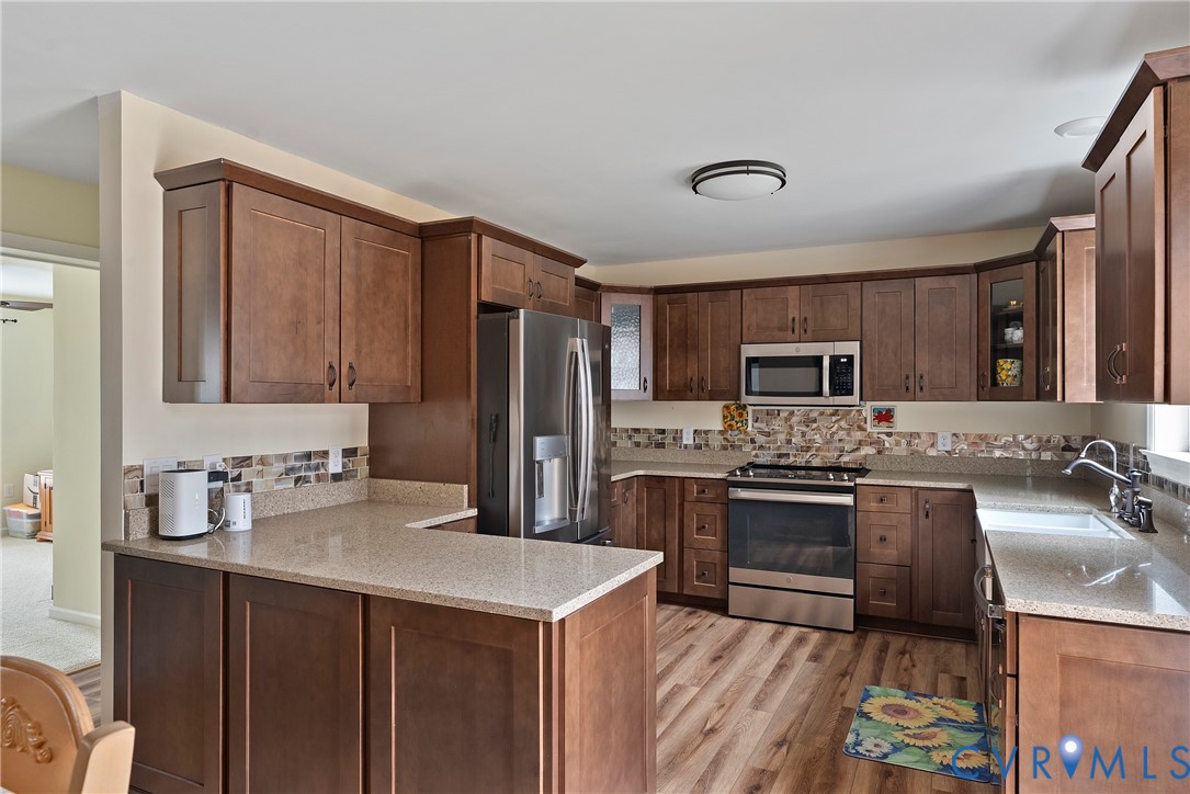 6115 Prospect Road Gloucester, VA 23061 - Photo 14 of 49 a kitchen with stainless steel appliances a sink stove refrigerator and cabinets