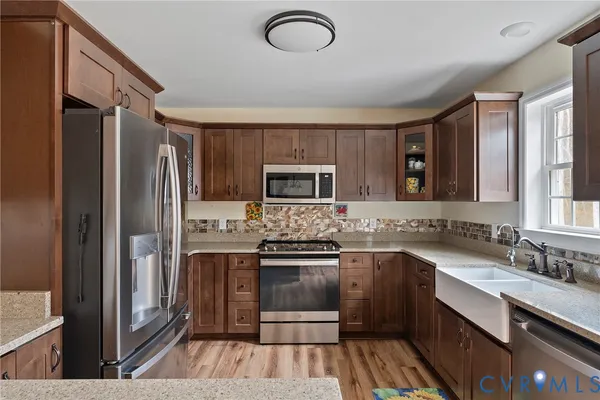 a kitchen with stainless steel appliances granite countertop a refrigerator and a stove top oven