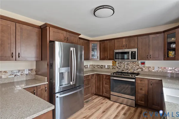 a kitchen with stainless steel appliances granite countertop a stove refrigerator sink and microwave
