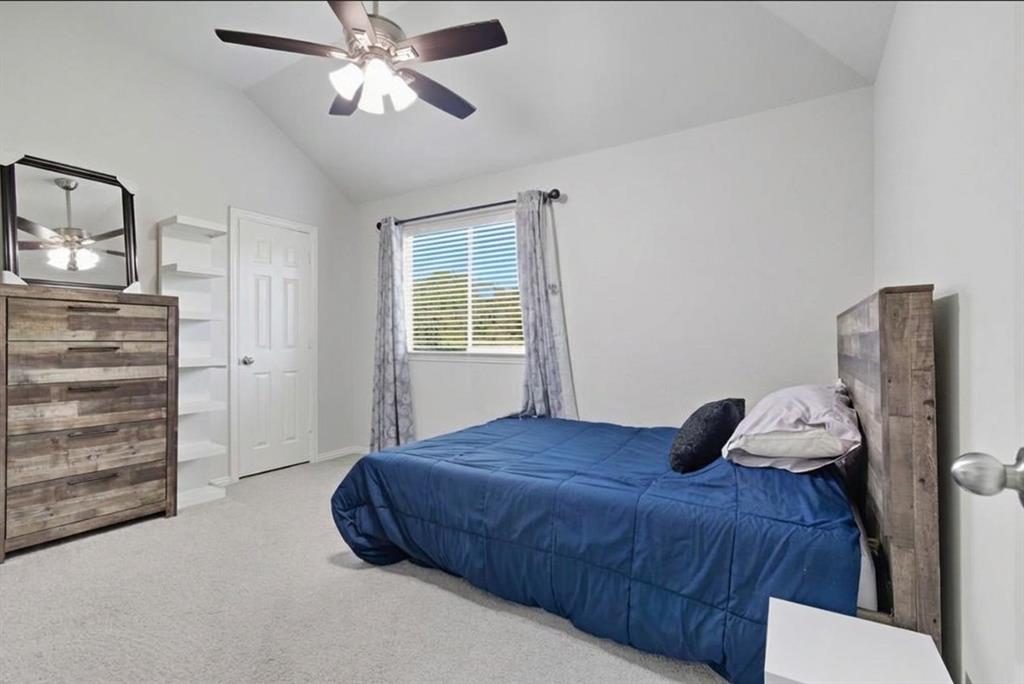 409 Springtree Road Lake Dallas, TX 75065 - Photo 33 of 40 Vaulted ceiling, ceiling fan with integrated lighting, white paneled door, built-in shelving, and carpet flooring