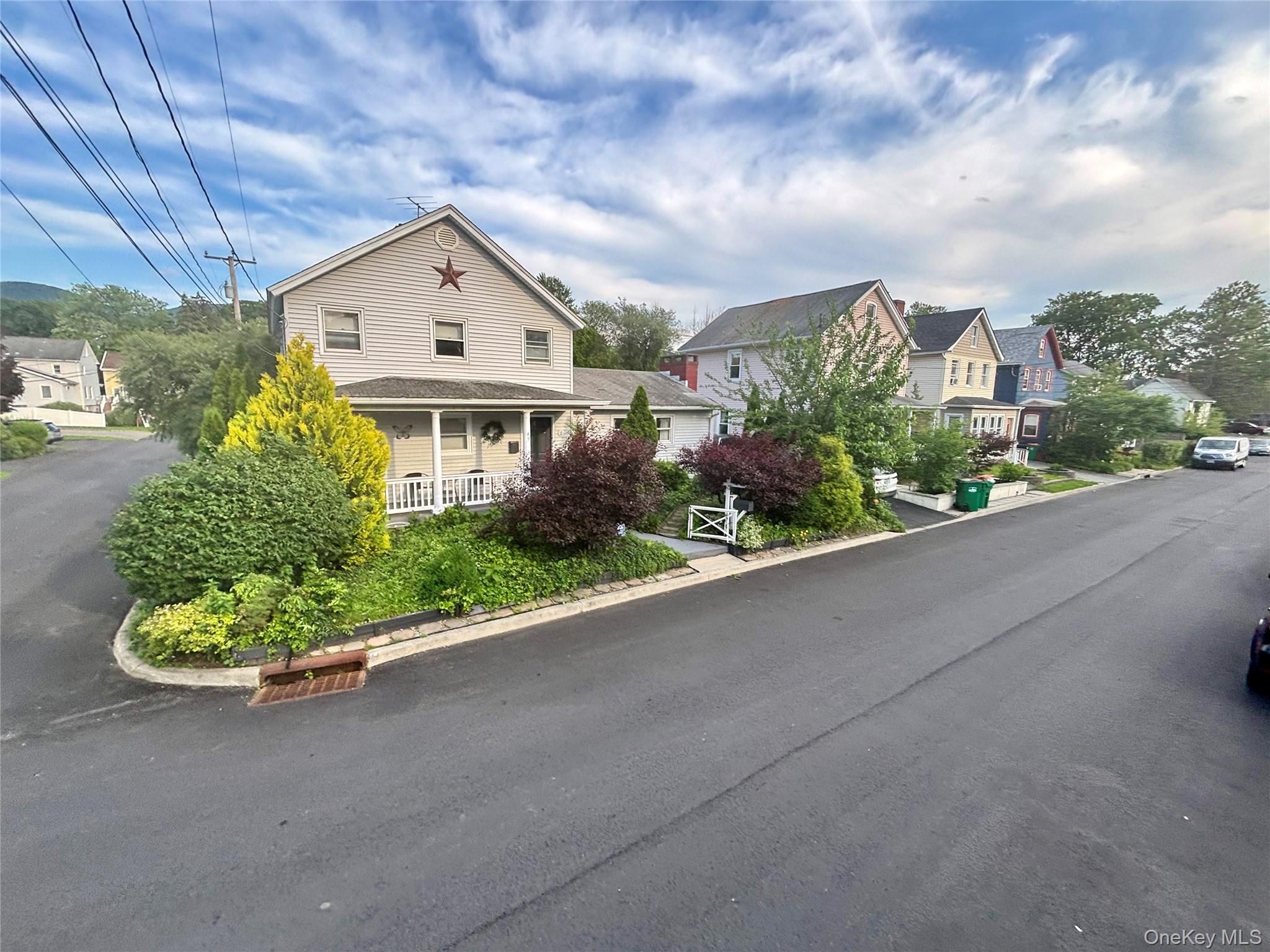 View of asphalt street with a residential view and curbs