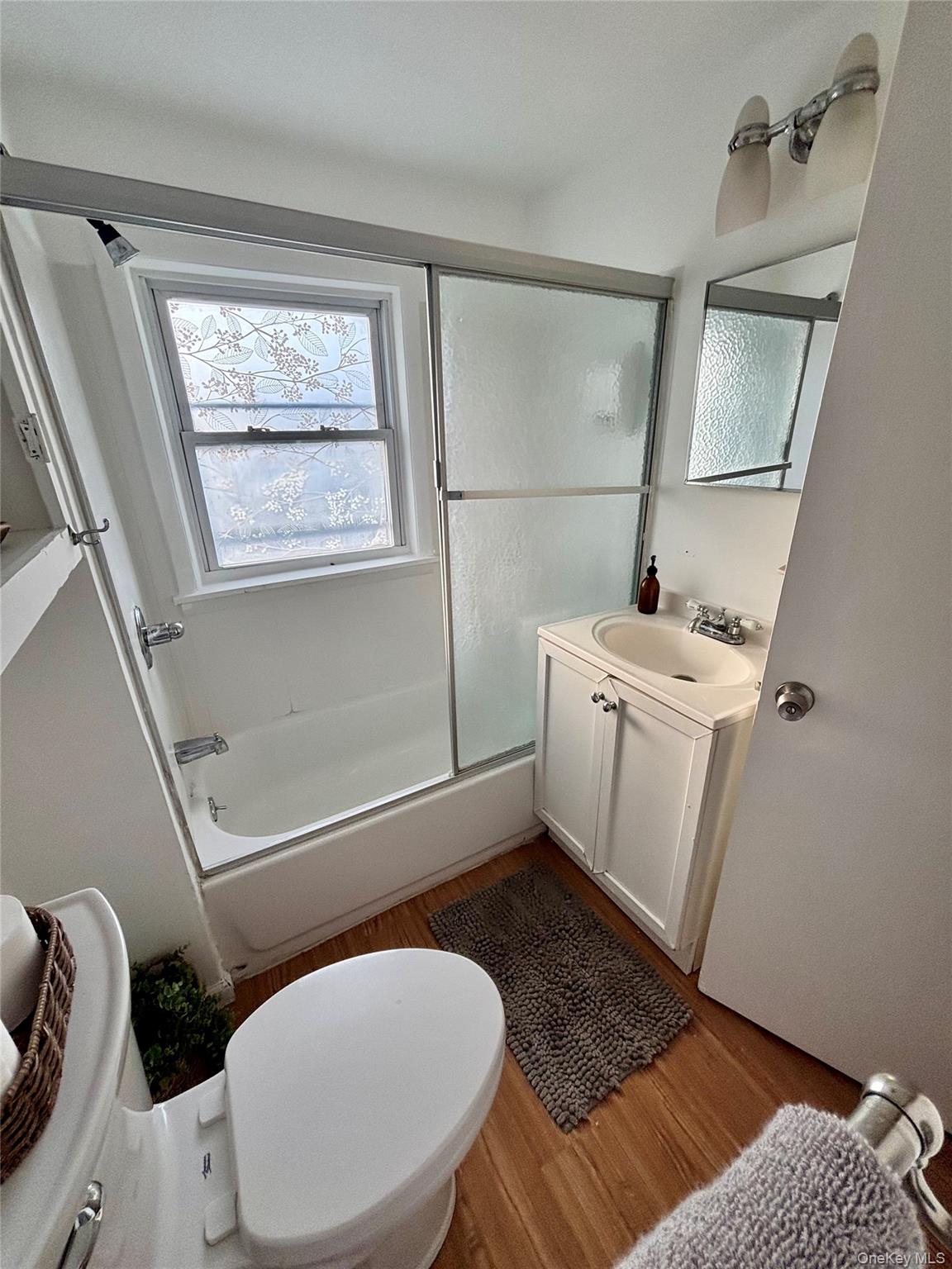 49 North Chestnut Street Beacon, NY 12508 - Photo 25 of 41 Bathroom with wood finished floors, vanity, toilet, and shower / bath combination with glass door