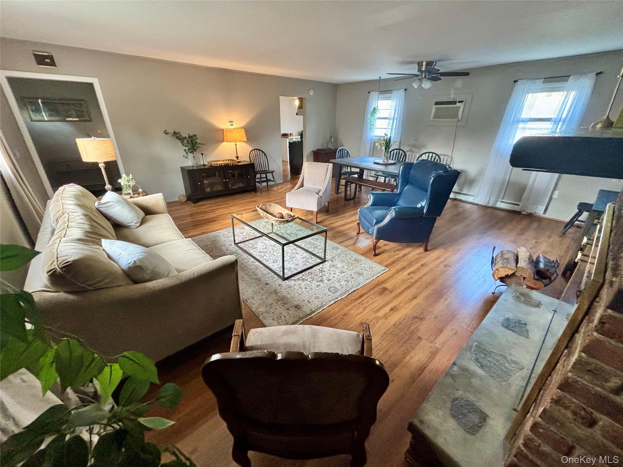 49 North Chestnut Street Beacon, NY 12508 - Photo 5 of 41 Living area with ceiling fan, an AC wall unit, and wood finished floors