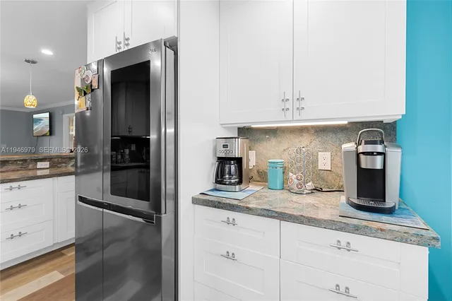 a kitchen with stainless steel appliances a sink stove refrigerator and cabinets