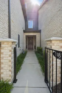a view of a brick house with a small yard