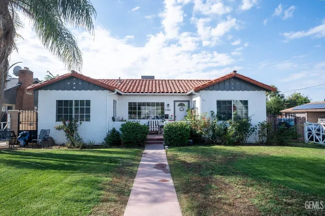 a front view of a house with a garden and plants