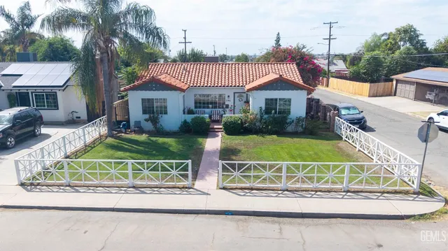 a view of a house with a big yard and potted plants