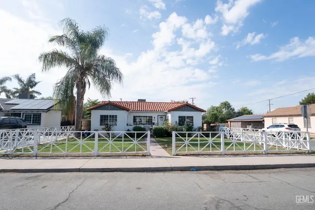 a front view of house with a yard and potted plants