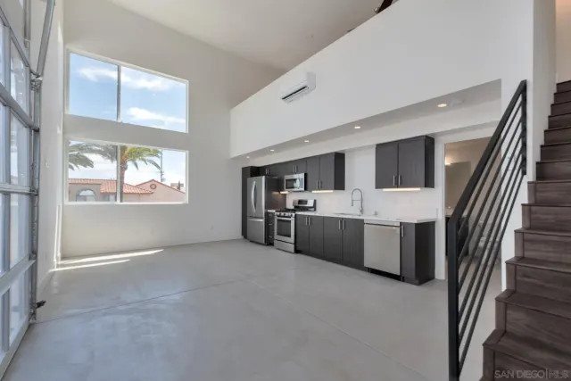 a large white kitchen with a sink stainless steel appliances and cabinets