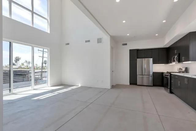 a view of a kitchen with refrigerator and a sink