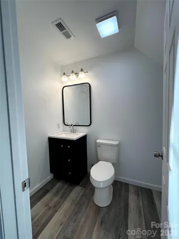 a bathroom with a toilet a sink and mirror