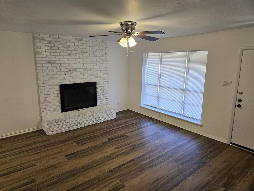 1011 South Perry Avenue Denison, TX 75020 - Photo 2 of 11 a view of an empty room with wooden floor fireplace and a window