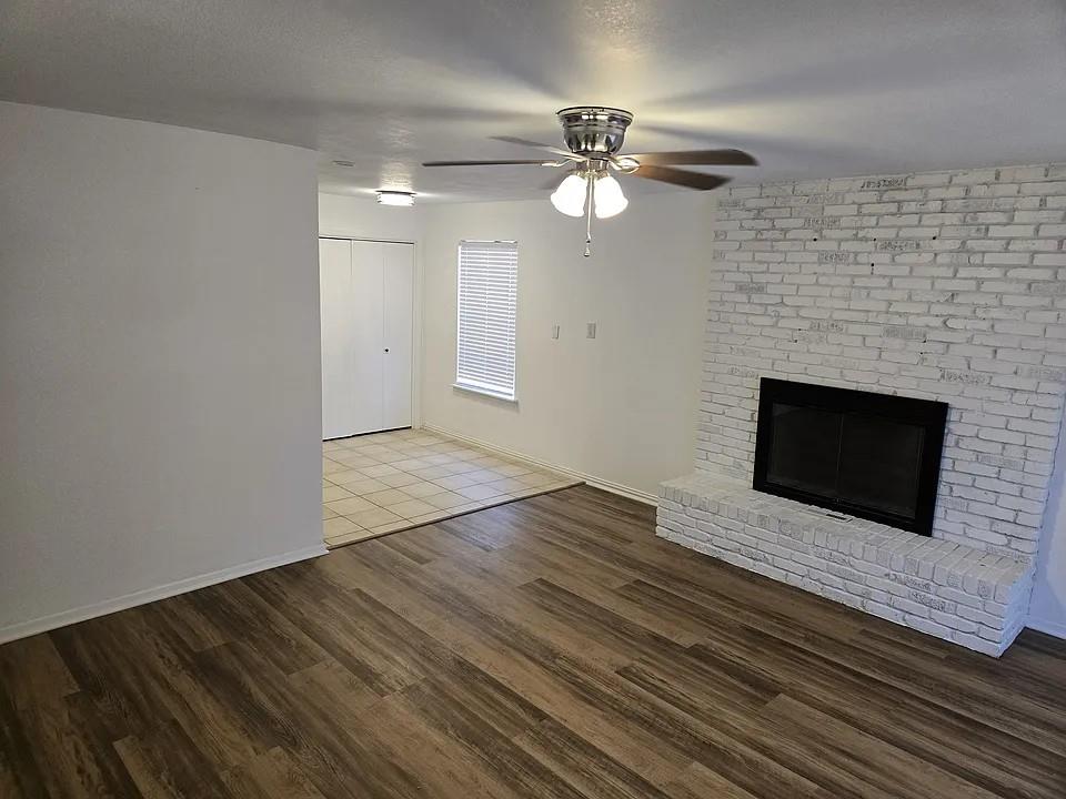 1011 South Perry Avenue Denison, TX 75020 - Photo 3 of 11 a view of an empty room with wooden floor and a fireplace