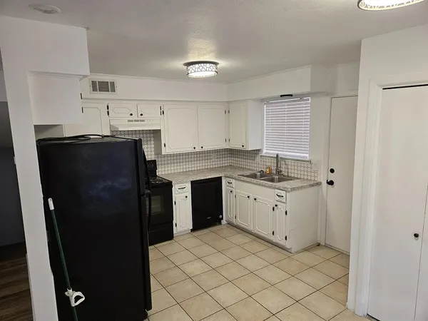 a kitchen with a refrigerator sink and cabinets