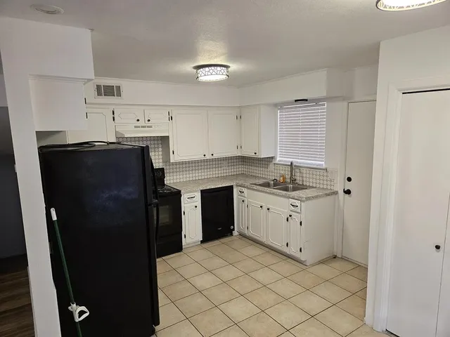 a kitchen with a refrigerator sink and cabinets
