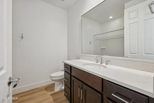 a bathroom with a sink a toilet a mirror and shower